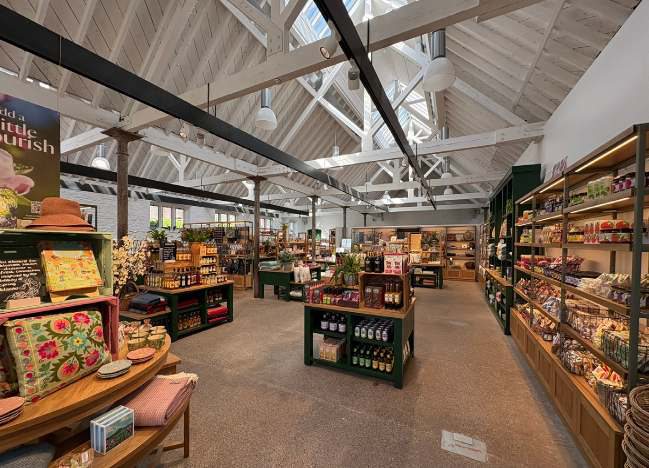 Inside the refurbished Cow Barn shop, with the timber roof structure retained above the new retail fit-out